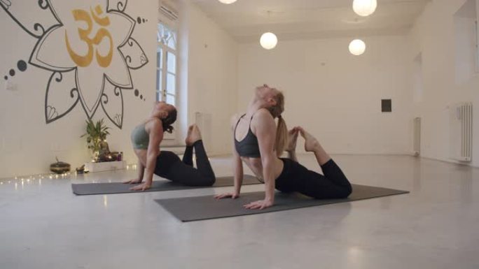 两个女人一起练习瑜伽时的慢动作视频