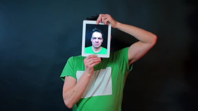 一个人通过平板电脑的屏幕展示情感。