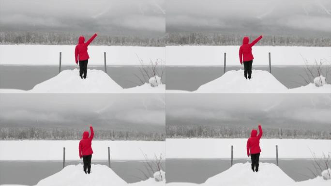 亚洲妇女在冬天在朱红色的湖边挥手
