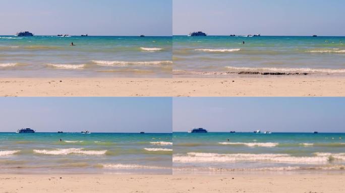 4K UHD。假日概念。局部海滩有海浪从海上来到海滩，有人类步行通道。软聚焦和对沙子有选择性的聚焦。
