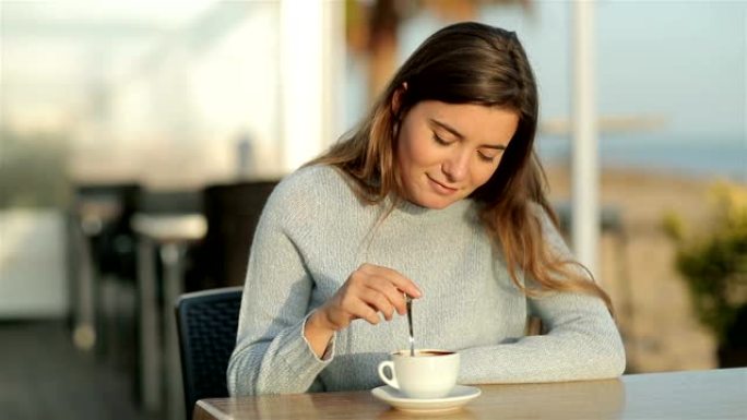 女孩在慢动作中坐在餐厅里搅拌咖啡