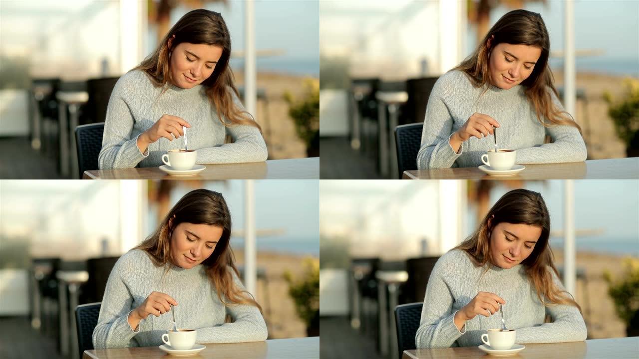 女孩在慢动作中坐在餐厅里搅拌咖啡