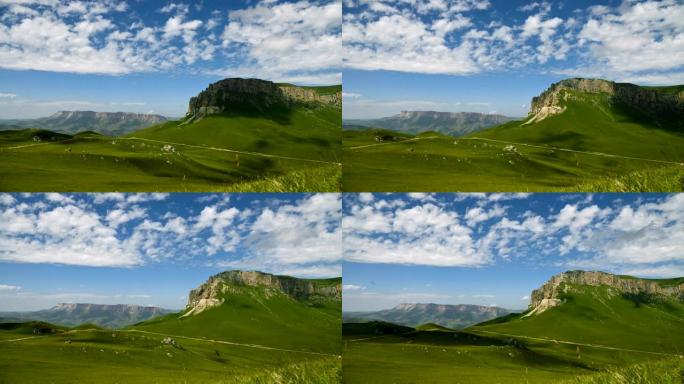 一个美丽的绿色高地白天的夏季景观的延时，岩石高原和云层和阴影从漂浮在它上面的夏天阳光明媚的日子。史诗