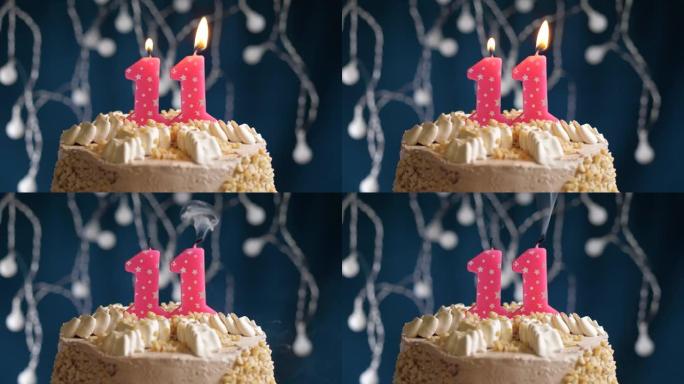 蓝色背景上有11号粉色蜡烛的生日蛋糕。蜡烛吹灭了。慢动作和特写视图