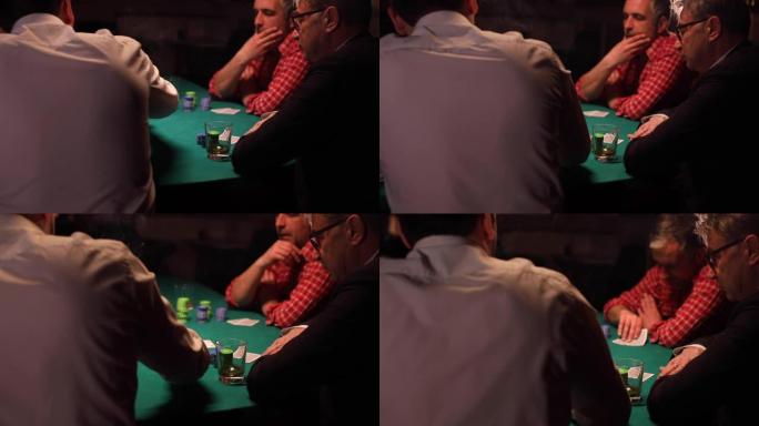 三个朋友在黑暗的房间里玩德州扑克