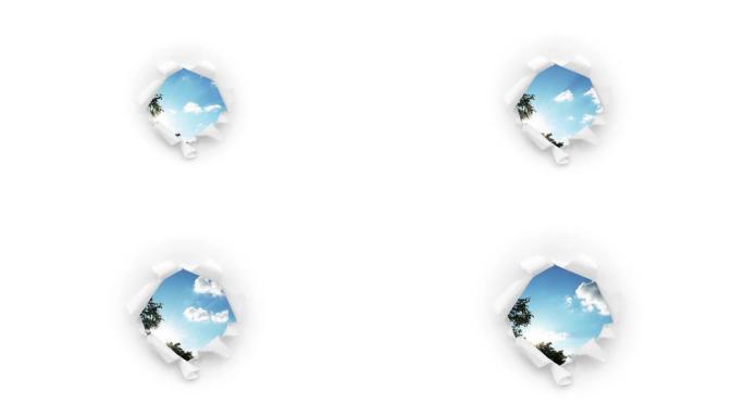 创意4k时间圈的视频，在蓝天中快速移动的云，可以通过一个圆孔在白纸上撕裂的边缘看到。意识扩张的概念，