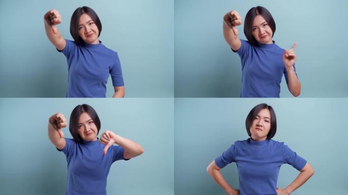 愤怒的亚洲女人看着孤立地站在蓝色背景上的相机。4k视频
