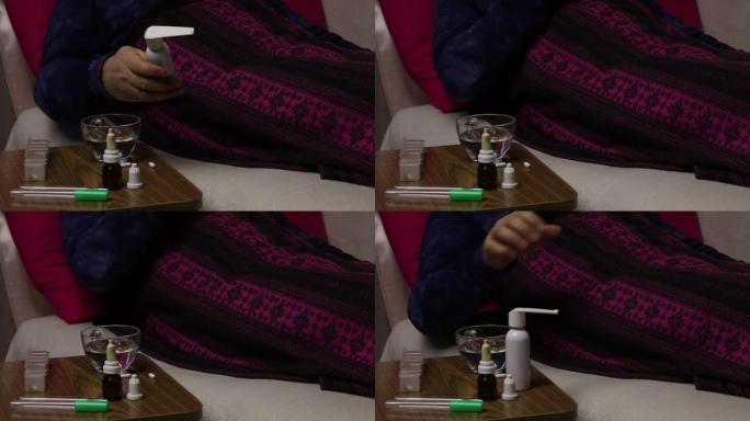 病人躺在铺着毯子的床上。他拿了一个喉咙喷雾，用它，然后放在架子上。椅子旁边是各种药物。