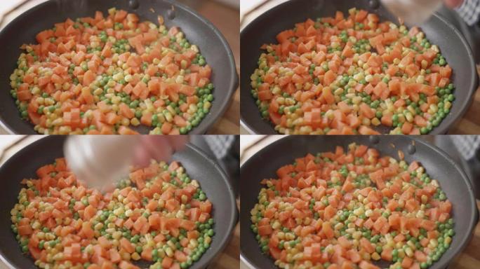 在煎锅中油炸胡萝卜，甜玉米和豌豆