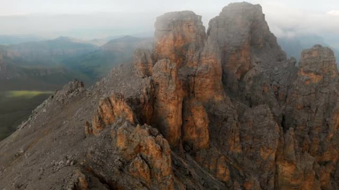 日落时无人机飞越尖锐的岩石露头的鸟瞰图。用于极端登山的陡峭的岩层山。飞行穿越旅行视频