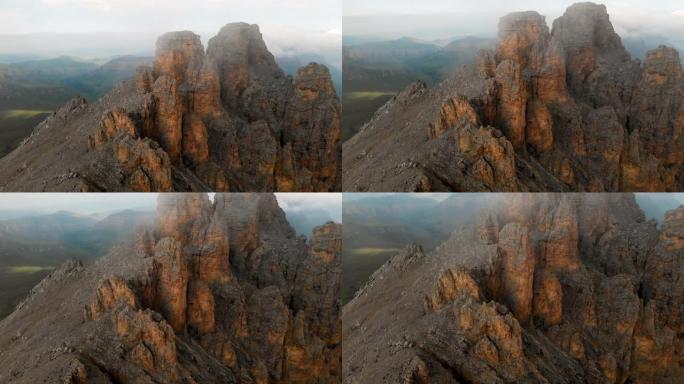 日落时无人机飞越尖锐的岩石露头的鸟瞰图。用于极端登山的陡峭的岩层山。飞行穿越旅行视频