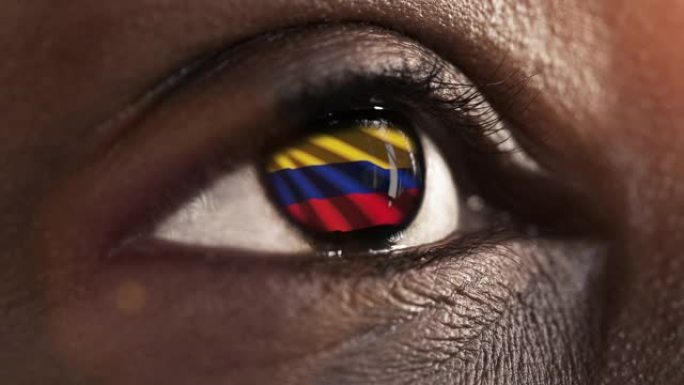 女人黑眼睛在近距离与国旗哥伦比亚在虹膜与风运动。视频的概念