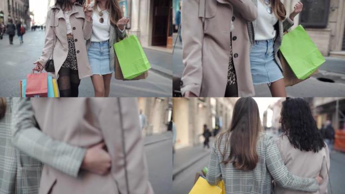 穿着时髦衣服的魅力女孩手里拿着五颜六色的购物袋走在市中心。微笑的时尚婴儿在街上享受人们对他们的关注。