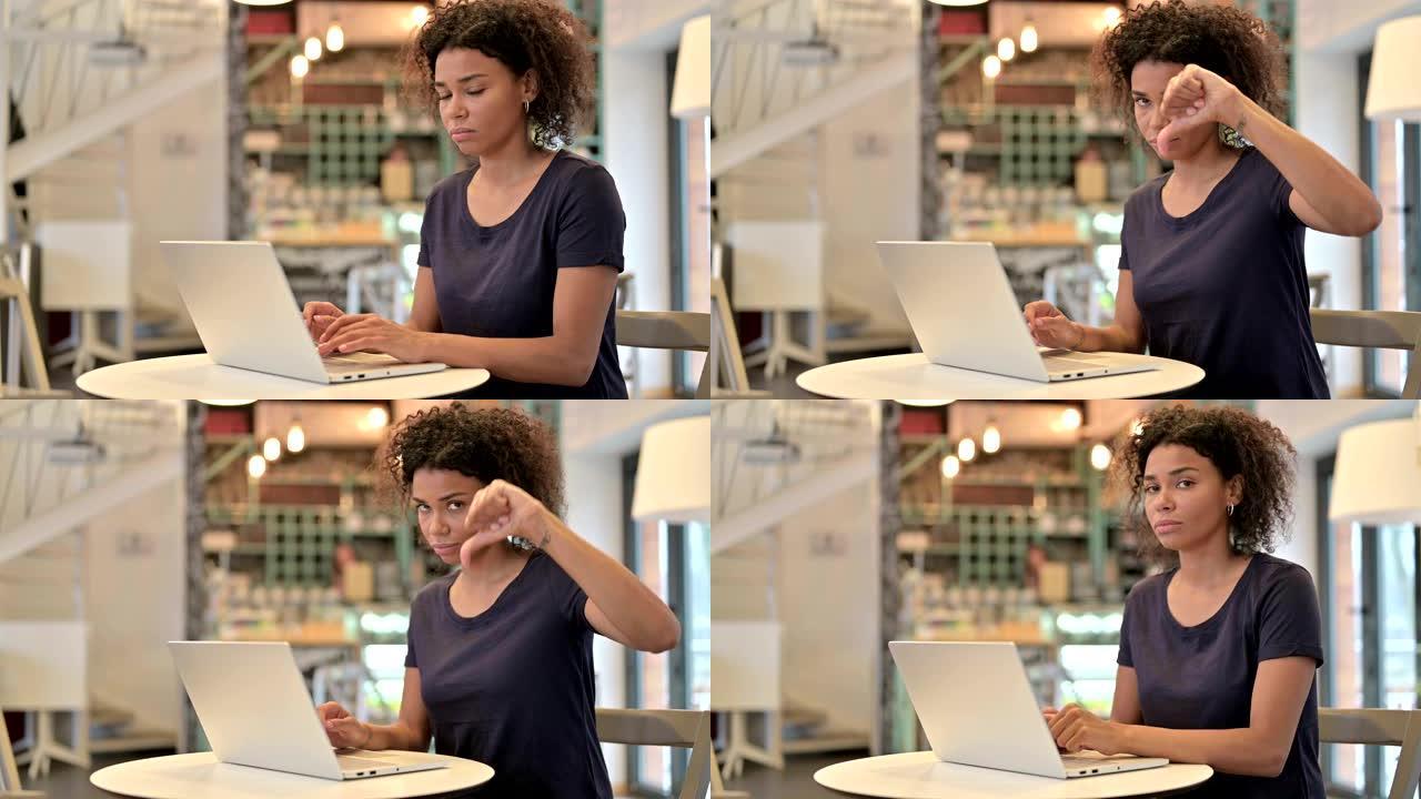 年轻的非洲妇女，笔记本电脑显示拇指朝下