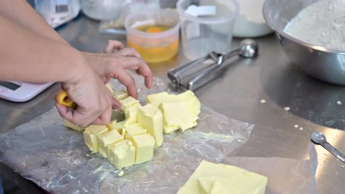 近距离手工切割黄油以烹饪饼干