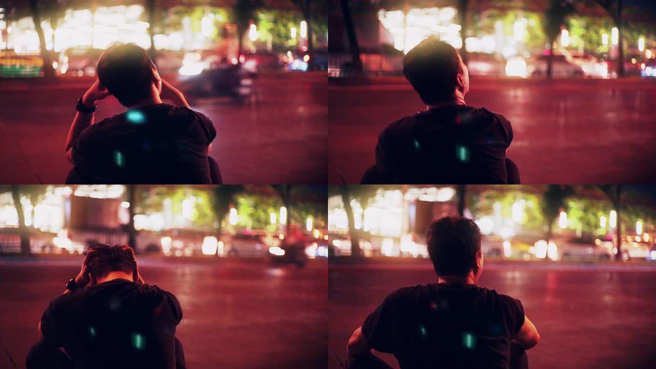 沮丧的人在黄昏时独自坐在街上。