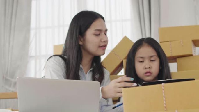 亚洲姐妹和姐妹使用笔记本电脑检查必须发送给客户的产品。在国内，中小企业，新的商业概念。