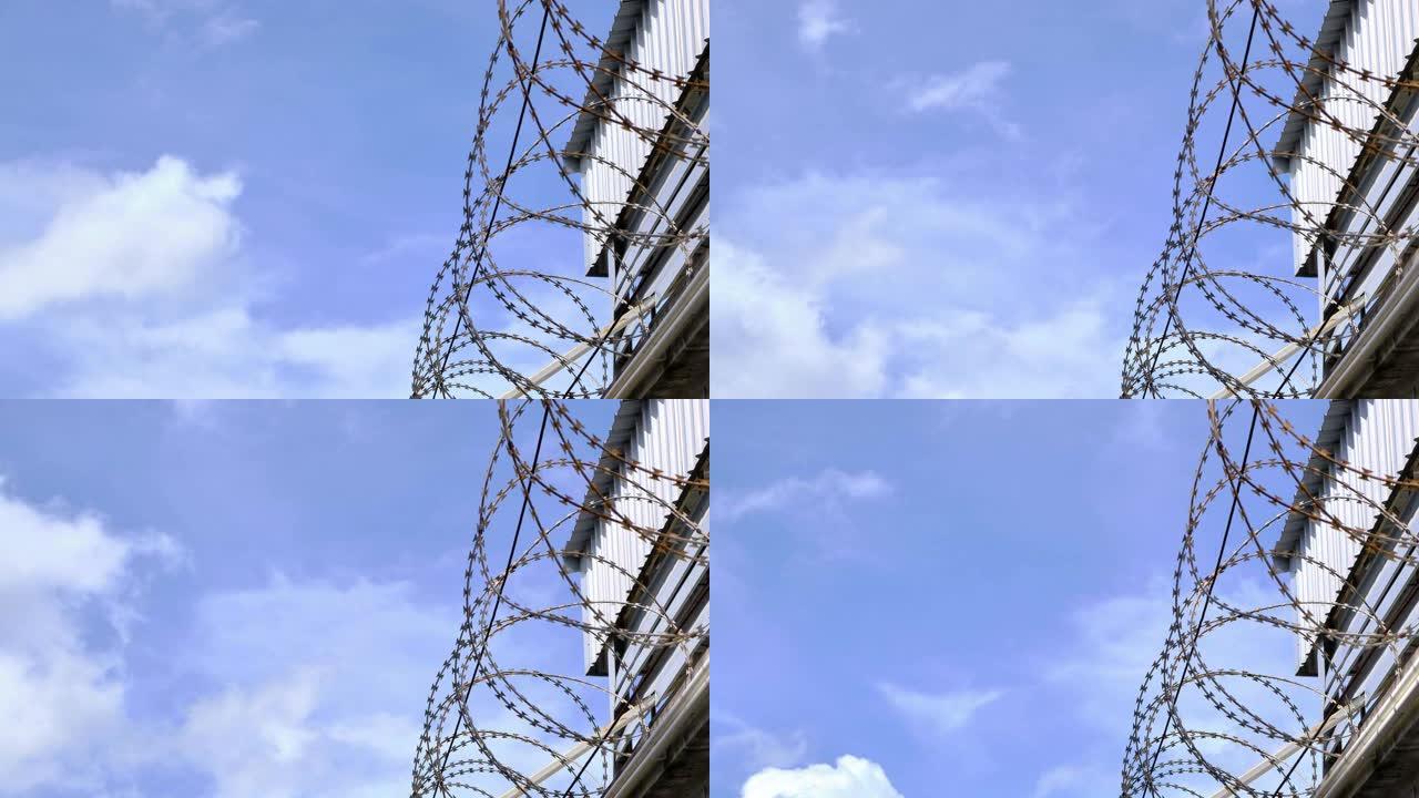 带有蓝天背景和移动的白云的铁丝网墙和建筑物，延时