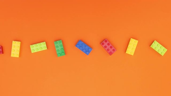 循环彩色砖块玩具在橙色背景上移动-停止运动