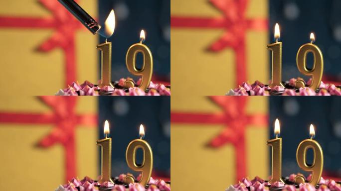 生日蛋糕19号点火器燃烧的金色蜡烛，蓝色背景礼物黄色盒子用红丝带绑起来。特写和慢动作