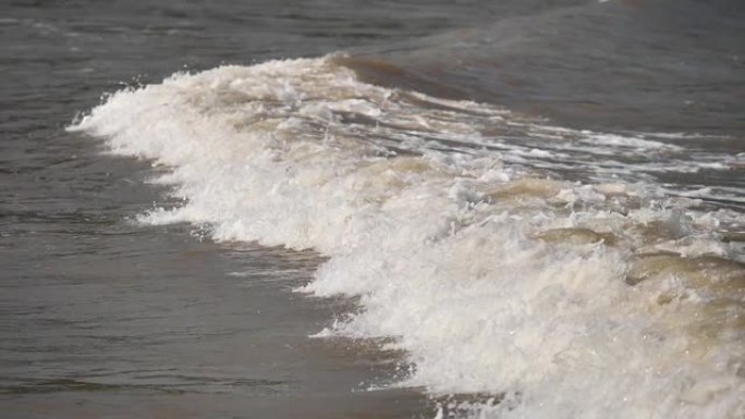 波浪冲上泥泞的海滩的特写镜头，高速相机，超慢动作，180 FPS，b滚动镜头。