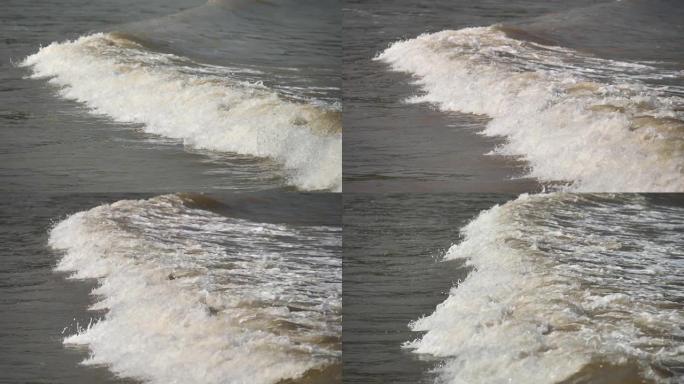 波浪冲上泥泞的海滩的特写镜头，高速相机，超慢动作，180 FPS，b滚动镜头。