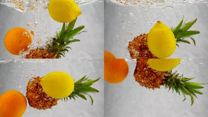 菠萝、橙子和柠檬落入水中，有很多小气泡。孤立的白色背景上的水果。