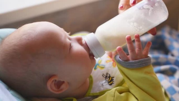 女人从瓶子里喂婴儿牛奶
