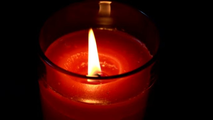 蜡烛火焰在黑暗背景上隔离的特写镜头