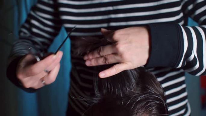 理发师用梳子和剪刀的手的特写。