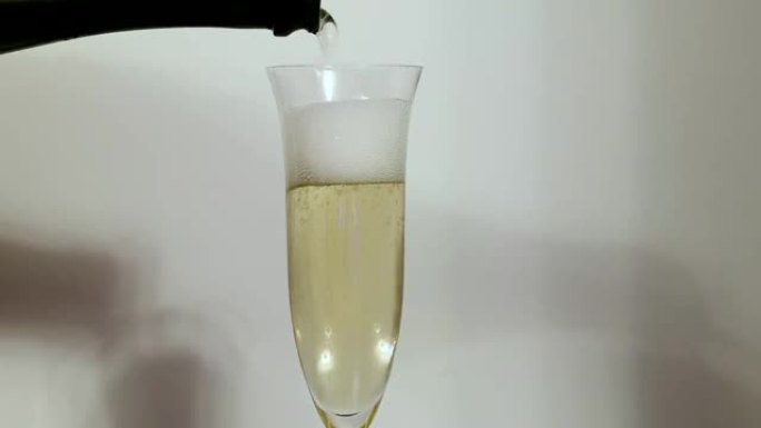 香槟被倒入背景玻璃杯中。美丽的背景。酒精概念。