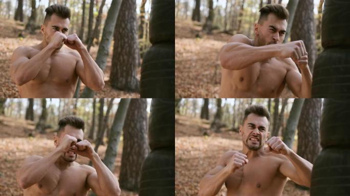 强壮裸躯干的家伙使拳击与他的手。秋天的森林。