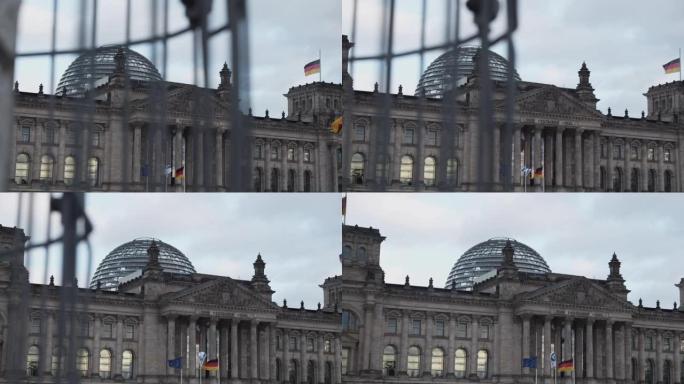 慢镜头:阴天的德国柏林，德国国旗迎风飘扬，背景是联邦议会大厦