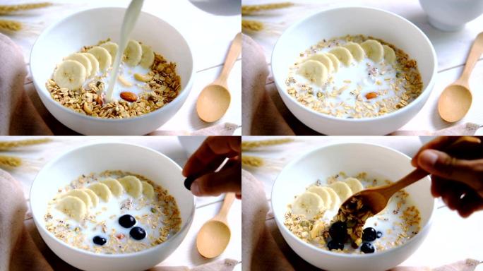 一碗格兰诺拉麦片杏仁和谷物配蓝莓和香蕉放在木制桌子上，健康早餐