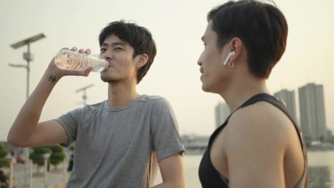 年轻的亚洲夫妇喝水跑步后休息