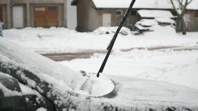 在雪地里开车。成熟的人在第一场雪后清洗汽车。活跃的老年人。