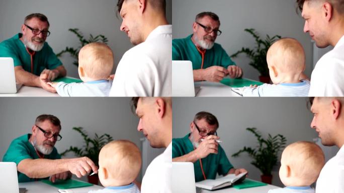 父亲和一个小儿子在儿科医生的预约。医生把病人的投诉写在笔记本电脑上。留着灰色胡须的男医生，医学和保健