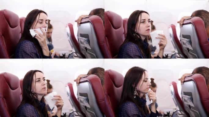 乘坐飞机的旅行者恶心。飞机上的女人在纸袋里呕吐。恶心飞机上的乘客。飞机上的湍流。