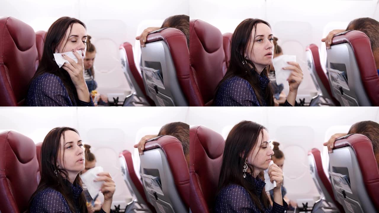 乘坐飞机的旅行者恶心。飞机上的女人在纸袋里呕吐。恶心飞机上的乘客。飞机上的湍流。