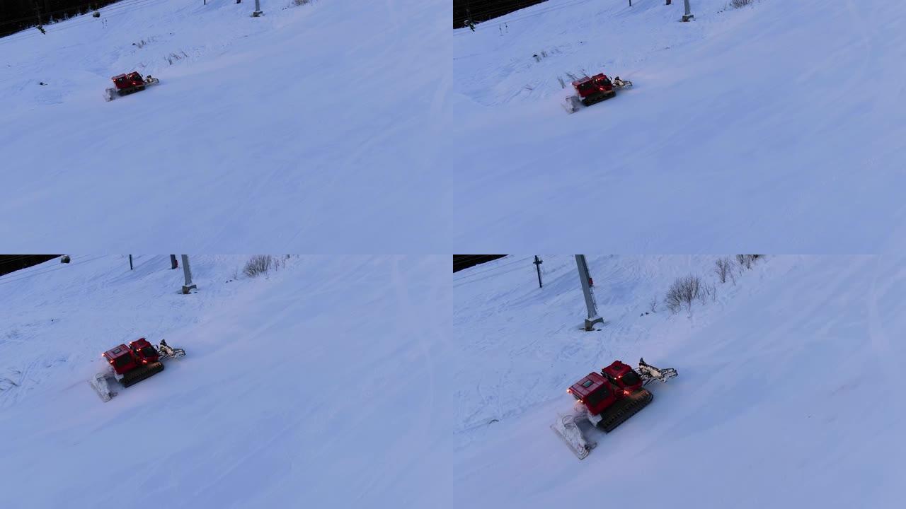 现代红色雪猫在滑雪缆车下驶向白色轨道