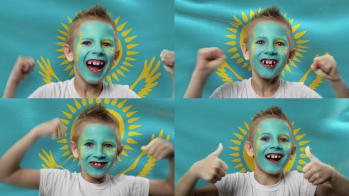 哈萨克斯坦国旗背景上的快乐粉丝。有着民族色彩的脸的快乐男孩。
