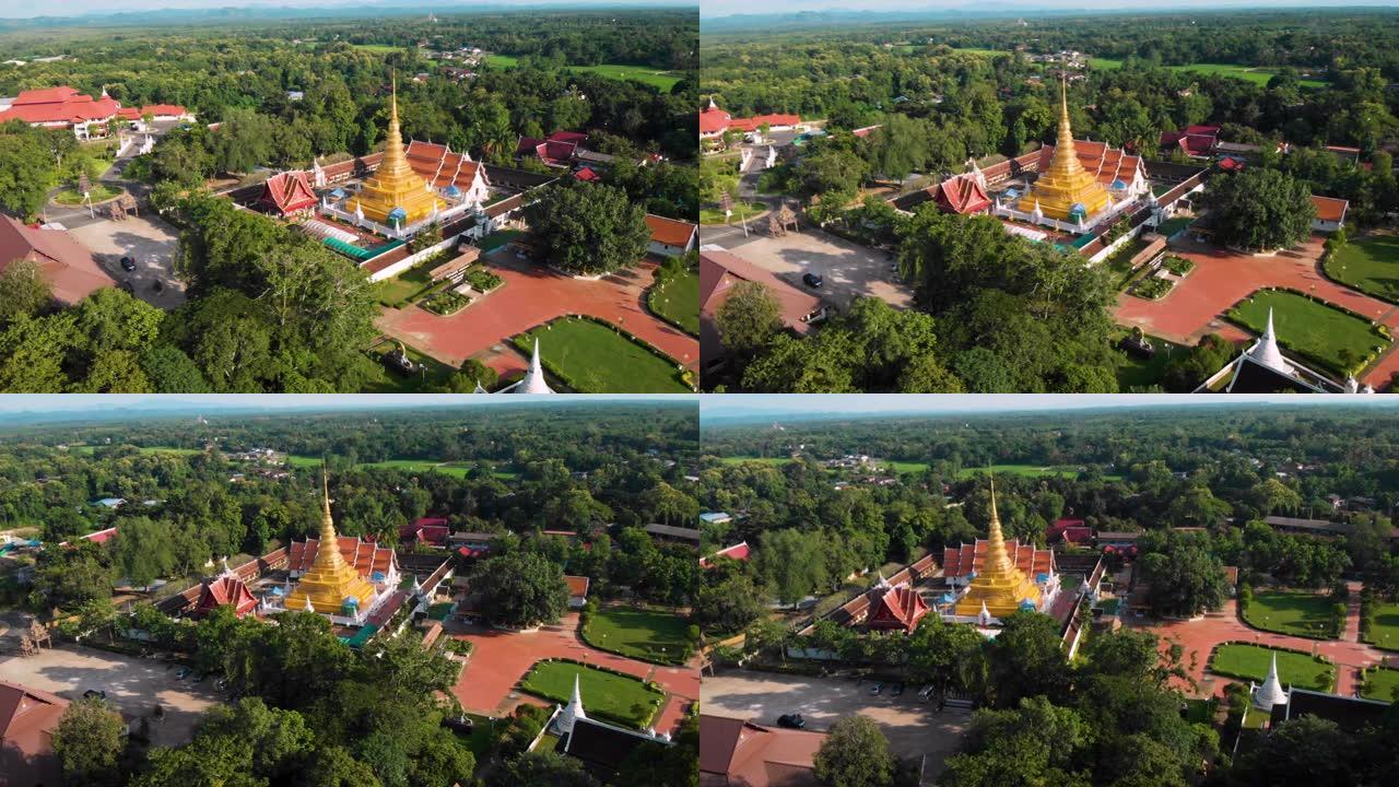 4k空中无人机拍摄-晴天的泰国佛教寺庙，绿树和灌木丛环绕的金色宝塔，橙色屋顶瓦，泰国佛教wat，宗教