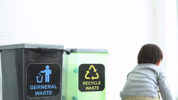德国男孩将塑料瓶分成可回收垃圾箱