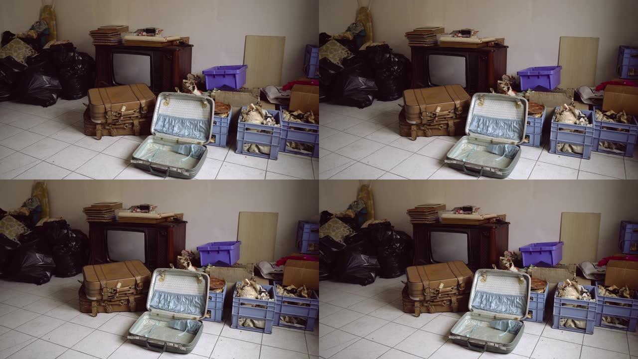 离开旧的公寓房间，准备好的包裹和包装有必要的东西的盒子，打开老式手提箱和复古电视。搬到带二手家具、家
