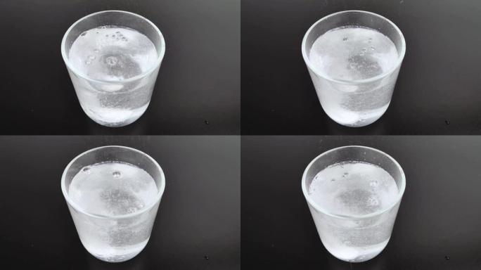 泡腾片溶解在玻璃中，发出大量气泡。溶解的气泡和药丸的宏视频。