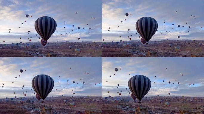 独自热气球在土耳其卡帕多细亚的白雪皑皑的风景下低飞