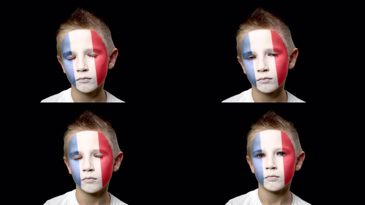 法国足球队的悲伤球迷。脸上涂着民族色彩的孩子。