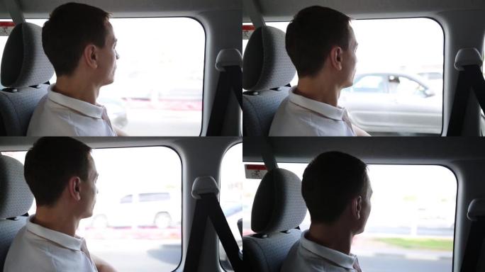 一名男性乘客乘坐出租车看着窗外。