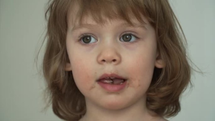 特写小脏有趣的3岁女孩吃大口子巧克力