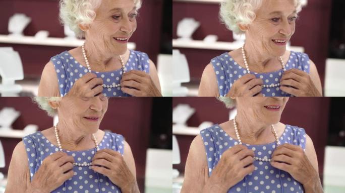 迷人的老年女士在珠宝店试穿珍珠项链